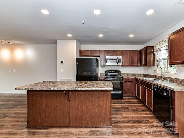 kitchen featuring a kitchen bar, sink, a center island, dark hardwood / wood-style floors, and black appliances