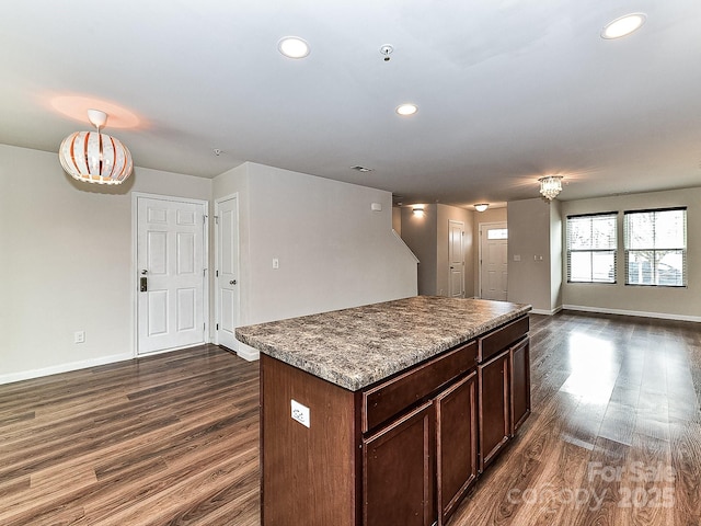 kitchen with a kitchen island and dark wood-type flooring