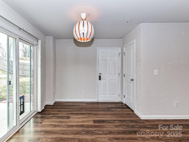 unfurnished dining area featuring dark wood-type flooring