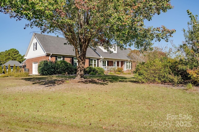 view of front of home with a garage, a porch, and a front lawn