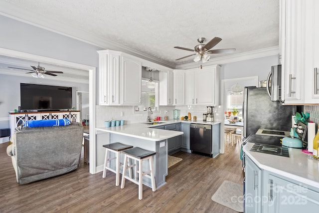 kitchen featuring sink, crown molding, a breakfast bar area, dishwasher, and white cabinetry