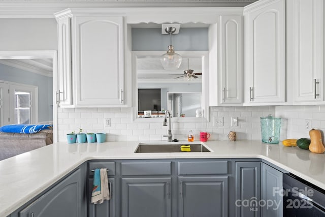 kitchen featuring gray cabinets, pendant lighting, white cabinetry, sink, and crown molding