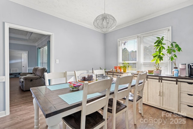 dining area with crown molding and wood-type flooring