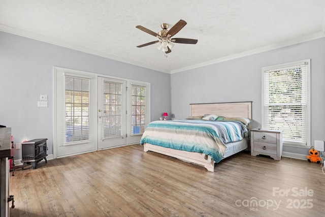 bedroom with hardwood / wood-style flooring, ornamental molding, a textured ceiling, and access to outside