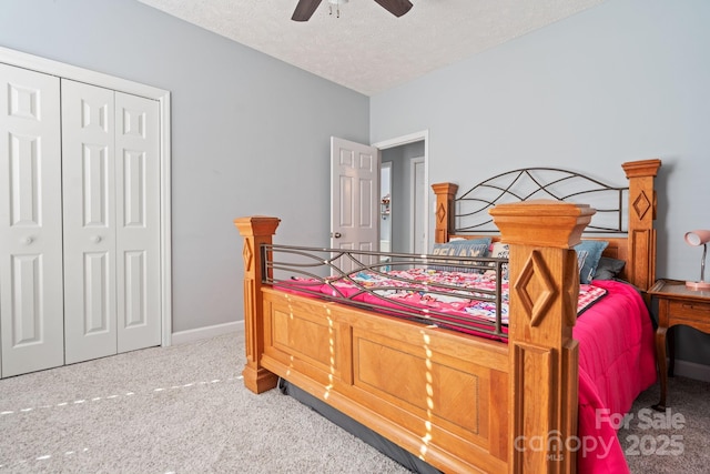 carpeted bedroom with ceiling fan, a closet, and a textured ceiling