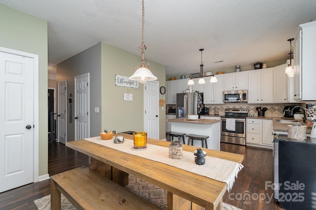 kitchen featuring appliances with stainless steel finishes, a center island, sink, and white cabinets