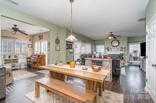 dining room with ceiling fan, dark hardwood / wood-style flooring, and a textured ceiling