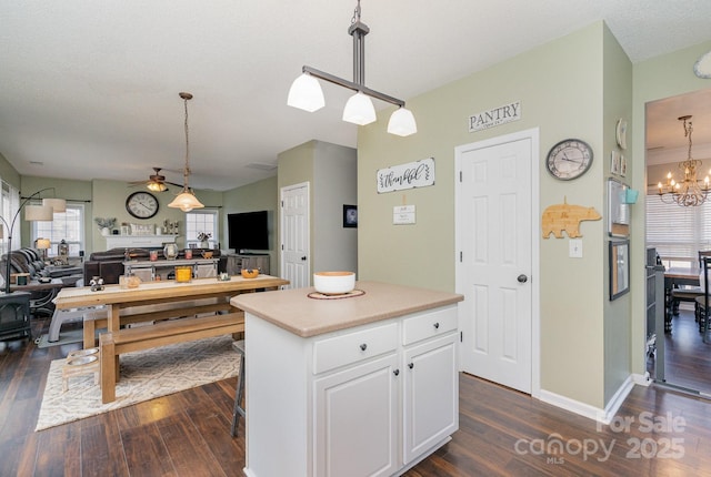 kitchen featuring white cabinetry, a center island, dark hardwood / wood-style floors, and decorative light fixtures