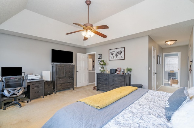 carpeted bedroom with ceiling fan and a tray ceiling