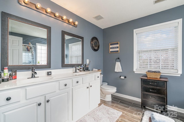 bathroom with vanity, a shower with shower door, and toilet