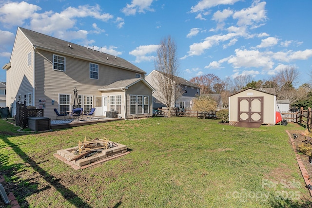 rear view of property with a fire pit, a yard, and a storage unit