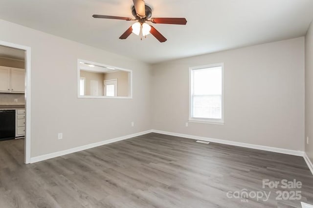 spare room with dark hardwood / wood-style floors and ceiling fan