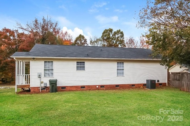 back of property featuring central AC unit and a lawn