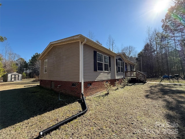 view of property exterior featuring a storage shed and a deck