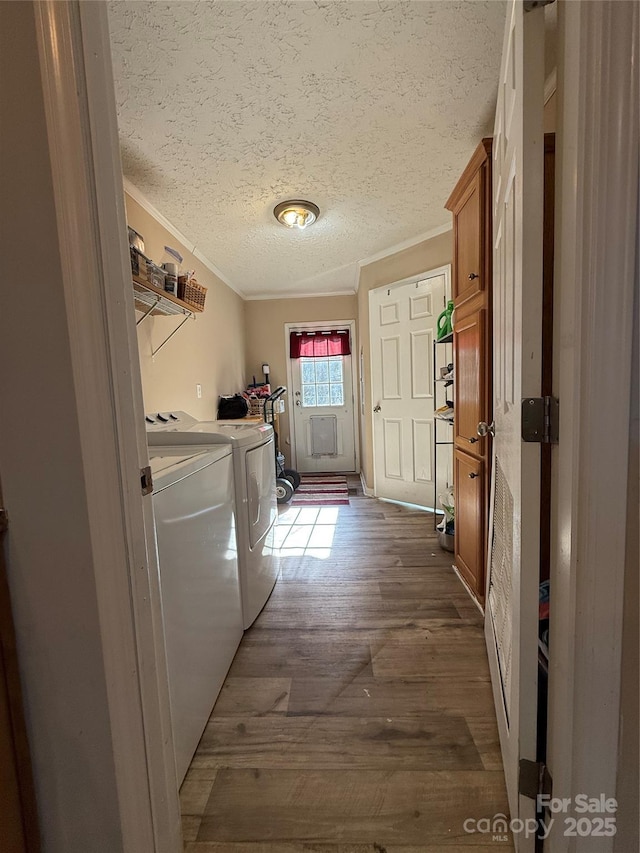 clothes washing area with ornamental molding, separate washer and dryer, dark wood-type flooring, and a textured ceiling