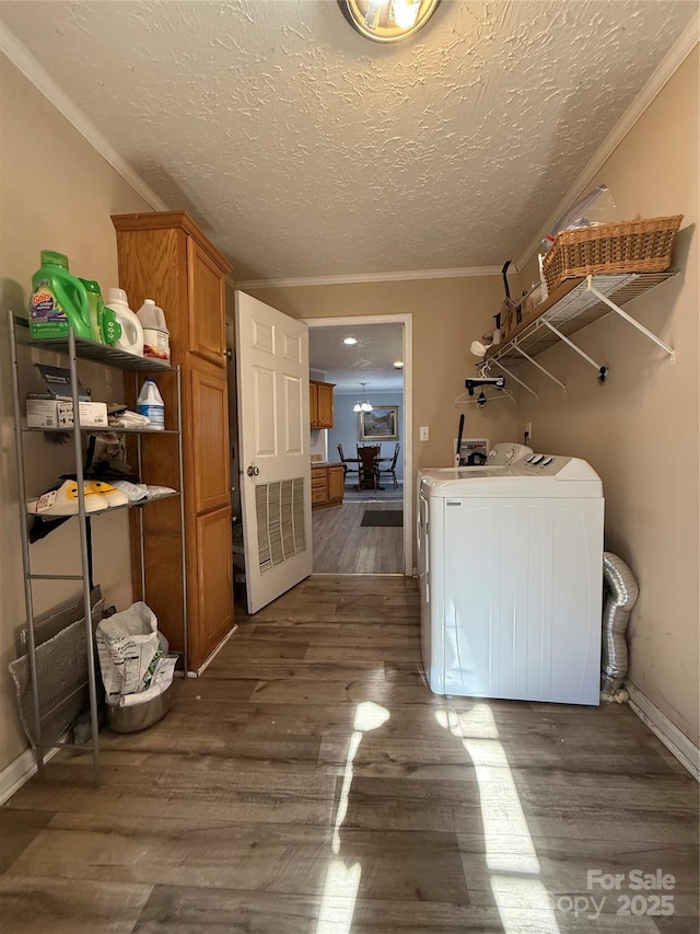 washroom with crown molding, dark hardwood / wood-style floors, washer and dryer, and a textured ceiling