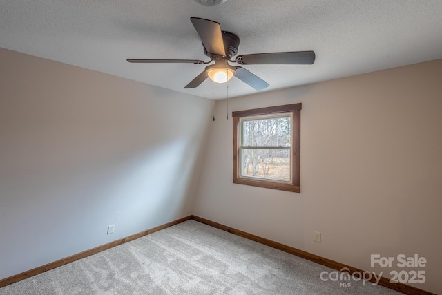 empty room featuring ceiling fan, carpet floors, and a textured ceiling