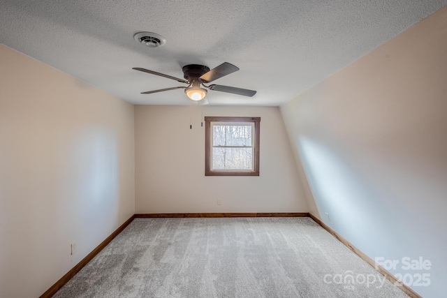 carpeted spare room with ceiling fan and a textured ceiling