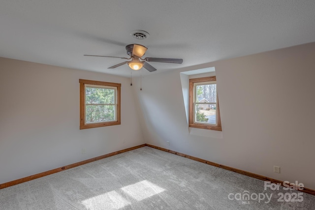 carpeted spare room with ceiling fan and a wealth of natural light