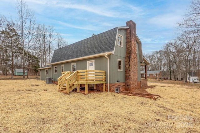 back of house featuring cooling unit and a wooden deck