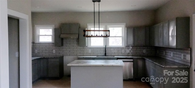 kitchen featuring a center island, a sink, a wealth of natural light, and decorative backsplash