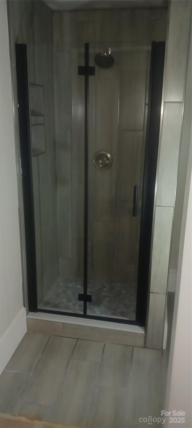 bathroom with a stall shower and baseboards