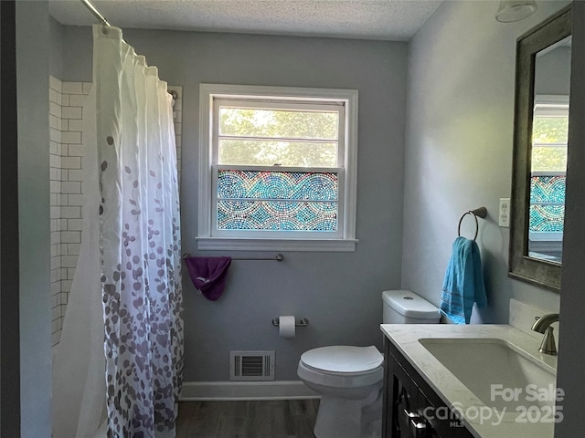 bathroom with vanity, hardwood / wood-style floors, a textured ceiling, and toilet