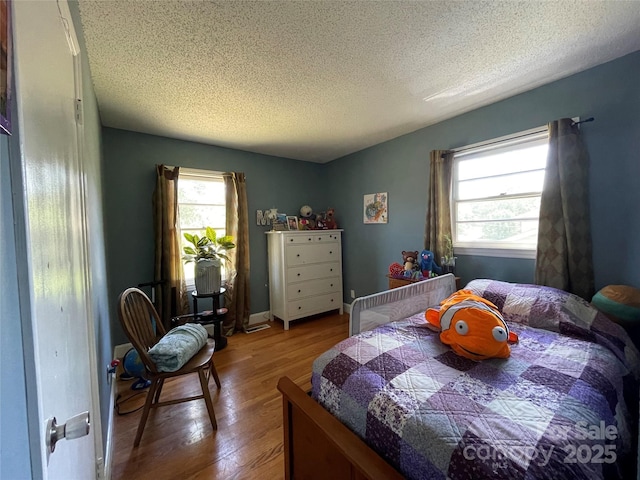 bedroom featuring hardwood / wood-style floors and a textured ceiling