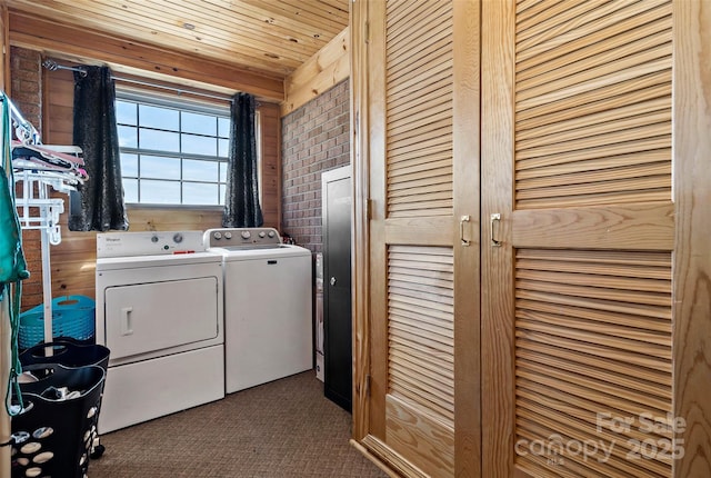 laundry room featuring dark colored carpet, wooden ceiling, independent washer and dryer, and wood walls