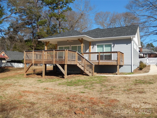 rear view of house with a yard, ceiling fan, and a deck