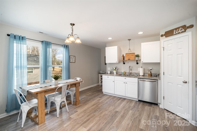 kitchen featuring decorative light fixtures, stainless steel dishwasher, and white cabinets