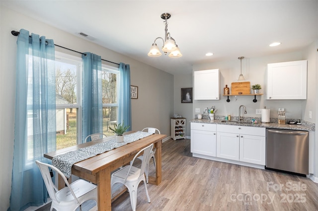 kitchen featuring white cabinets, decorative light fixtures, sink, and dishwasher