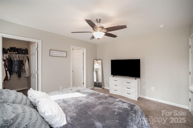 carpeted bedroom with ceiling fan, a spacious closet, and a closet