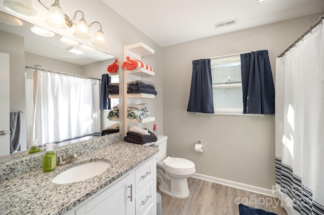 bathroom with hardwood / wood-style flooring, vanity, and toilet