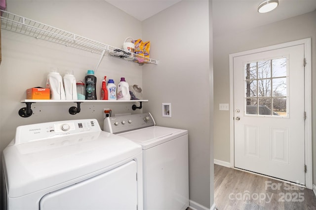 laundry room featuring washing machine and dryer and light hardwood / wood-style flooring