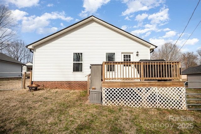 back of house featuring a deck and a lawn