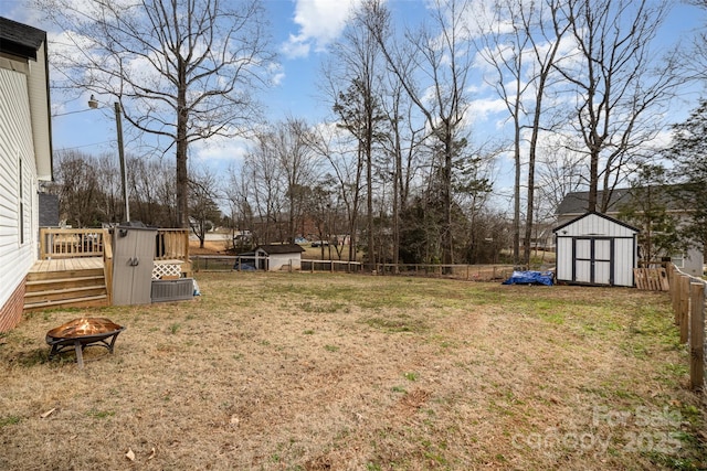 view of yard featuring a storage shed and a fire pit