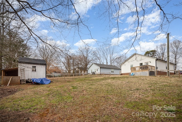 view of yard featuring a storage unit and a deck