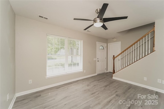 foyer entrance with ceiling fan and light hardwood / wood-style flooring