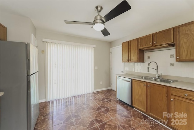 kitchen with appliances with stainless steel finishes, sink, backsplash, and ceiling fan