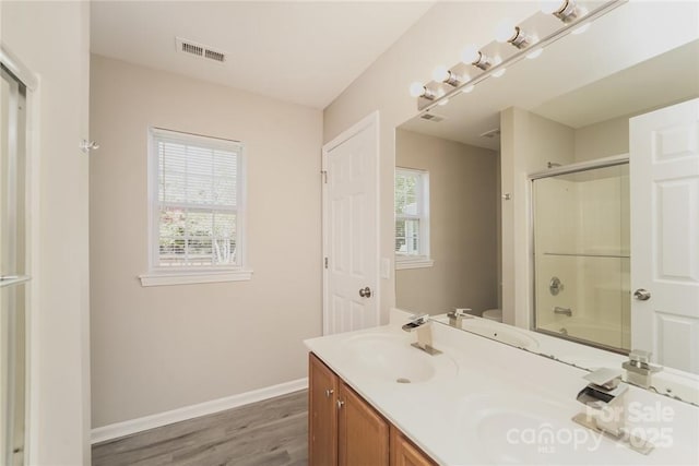 full bathroom featuring bath / shower combo with glass door, wood-type flooring, vanity, and toilet