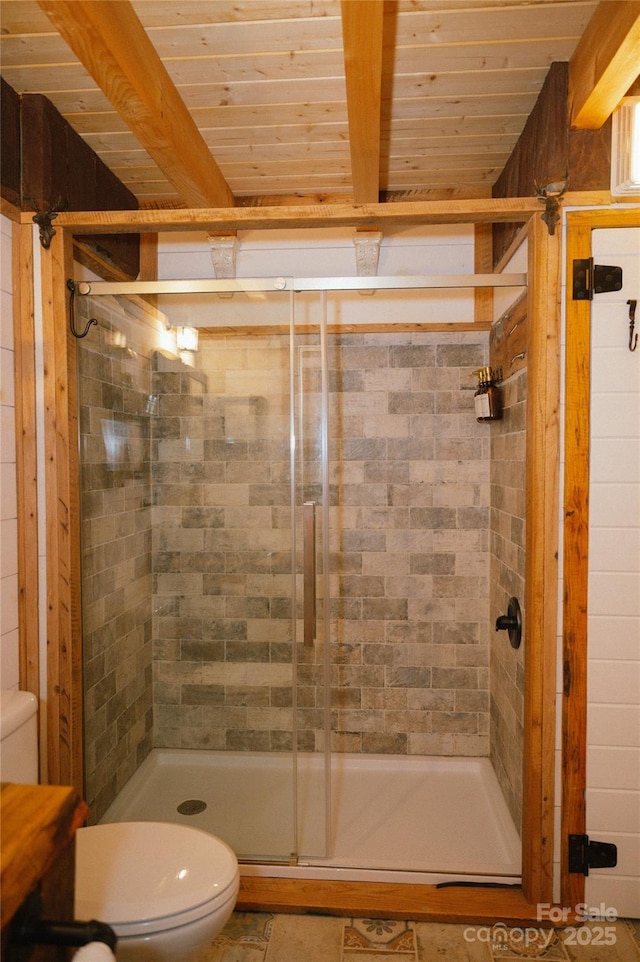 bathroom featuring wood ceiling, a shower with shower door, toilet, and beamed ceiling