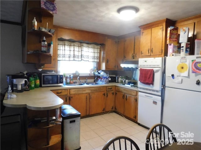 kitchen featuring white appliances, sink, and light tile patterned floors