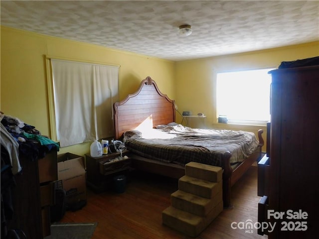 bedroom with dark wood-type flooring and a textured ceiling