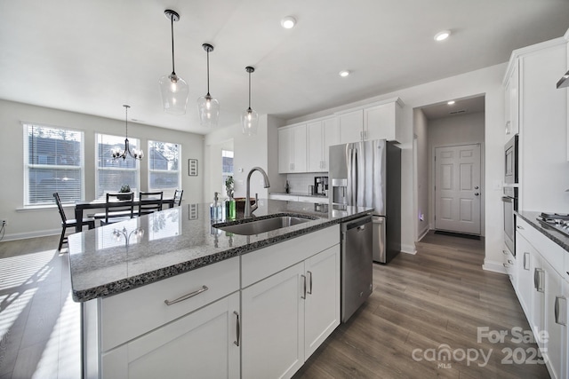 kitchen featuring appliances with stainless steel finishes, sink, an island with sink, and white cabinets