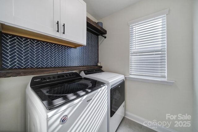 laundry room featuring cabinets, washing machine and dryer, and light tile patterned floors