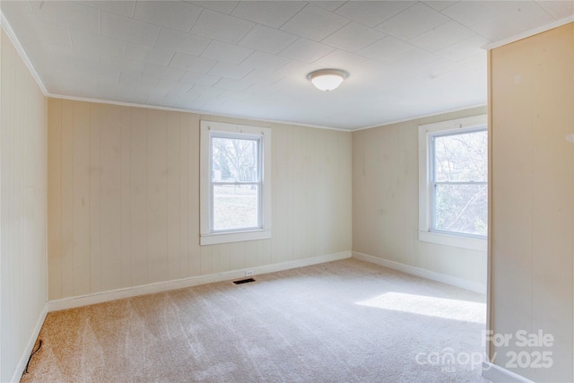 carpeted empty room featuring crown molding