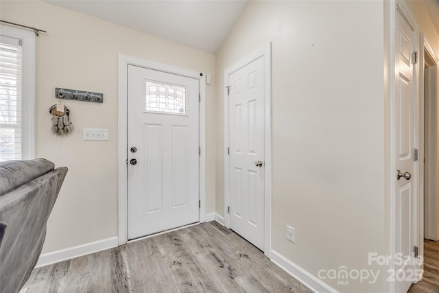 entryway featuring vaulted ceiling and light wood-type flooring