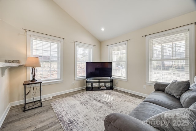 living room featuring lofted ceiling, plenty of natural light, and light hardwood / wood-style flooring