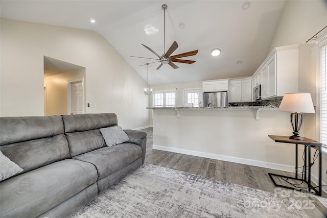 living room featuring lofted ceiling, hardwood / wood-style floors, and ceiling fan